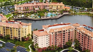 Un hotel grande con varias edificaciones, un patio central y un lago.