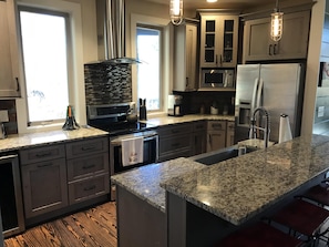 Enjoy cooking in this well-lit kitchen with a large island and stainless steel appliances.