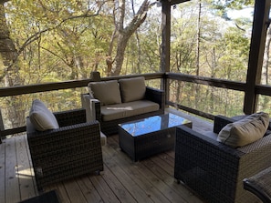 Relax in a serene outdoor space with a sofa, table, and wicker chairs.