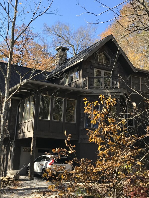 Enjoy the expansive views from the upper balcony, featuring large windows and a garage with a car.