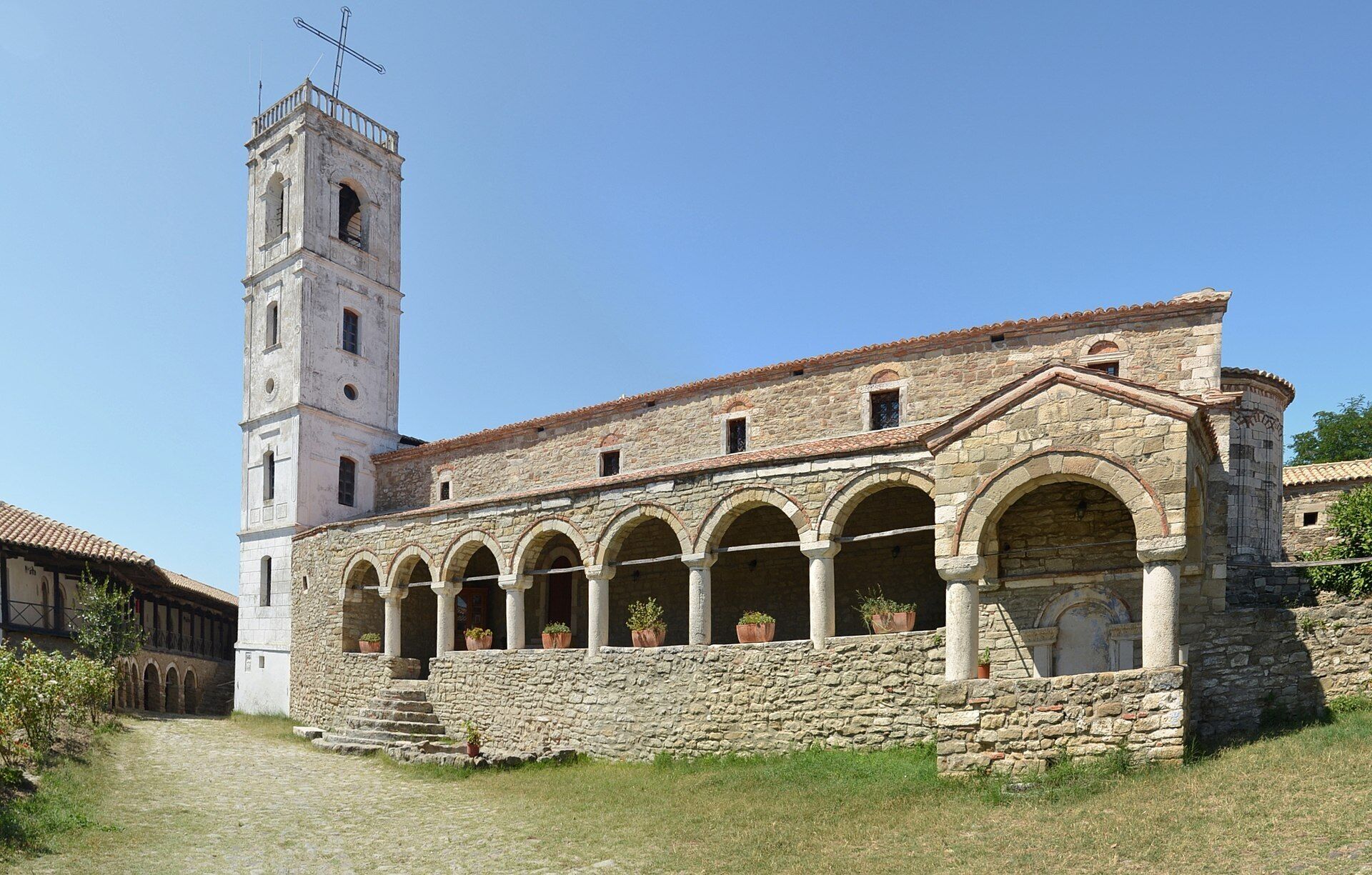 Un bâtiment historique en pierre, doté d’un clocher et de fenêtres en arc de cercle.