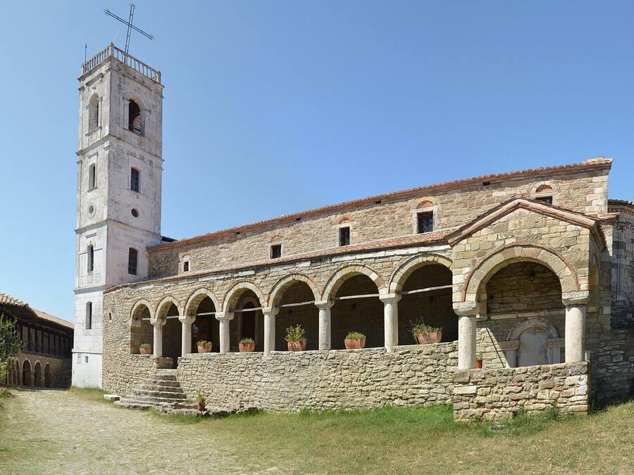 Un bâtiment historique en pierre, doté d’un clocher et de fenêtres en arc de cercle.