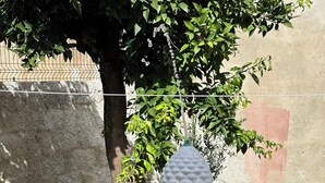 Une fontaine à plusieurs niveaux, dont l’eau jaillit en cascade, entourée d’une piscine aux carreaux bleus et d’un mur de pierre.
