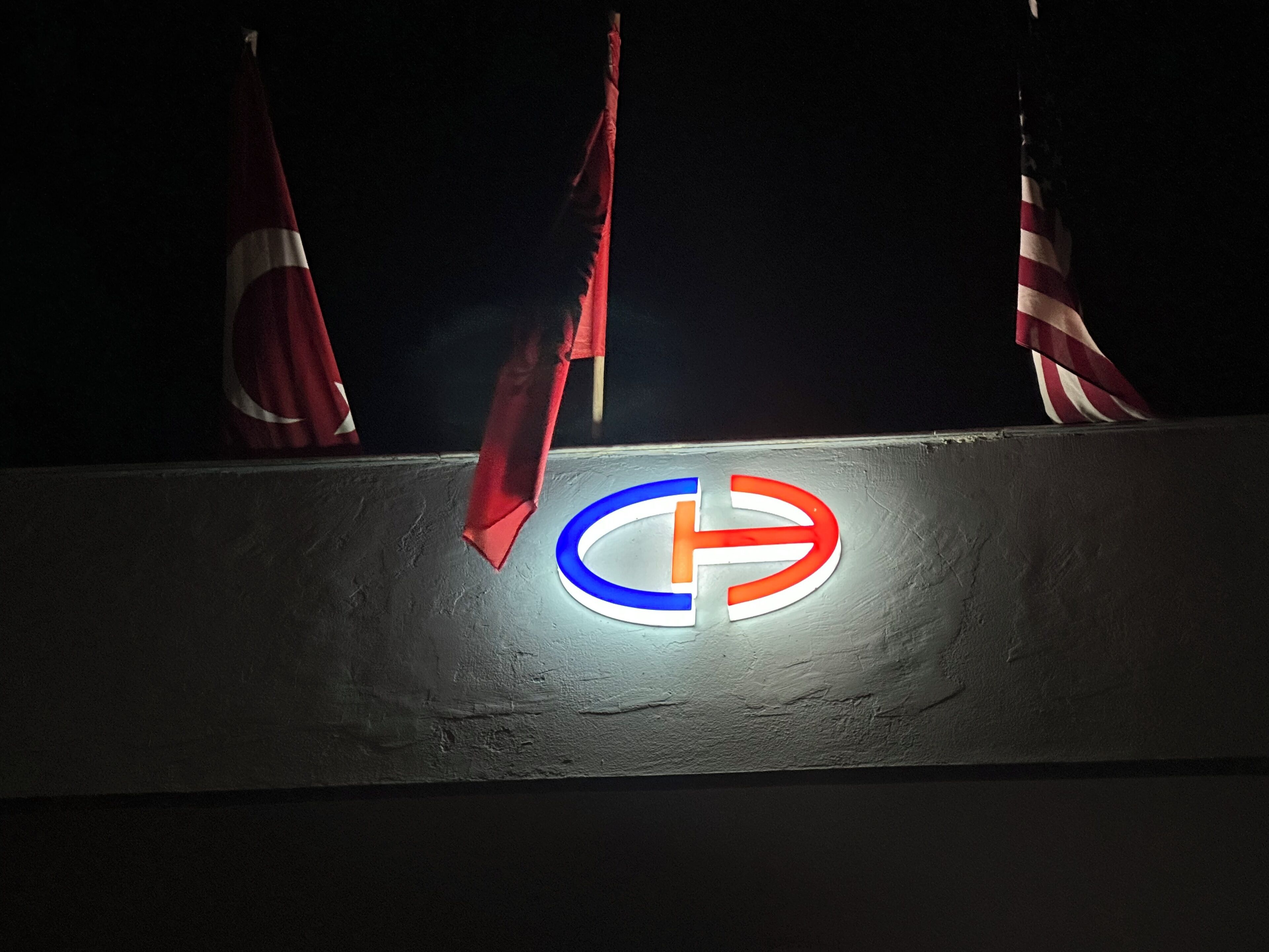 Un edificio con un logotipo destacado que presenta un diseño circular azul y rojo con una 'T' blanca en el centro.
