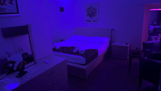 Une chambre à coucher avec un lit, des tables de chevet, une commode et un miroir.