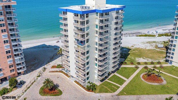 Ein Hochhaus-Hotel mit mehreren Balkonen, Blick auf den Strand und einem angelegten Innenhof.