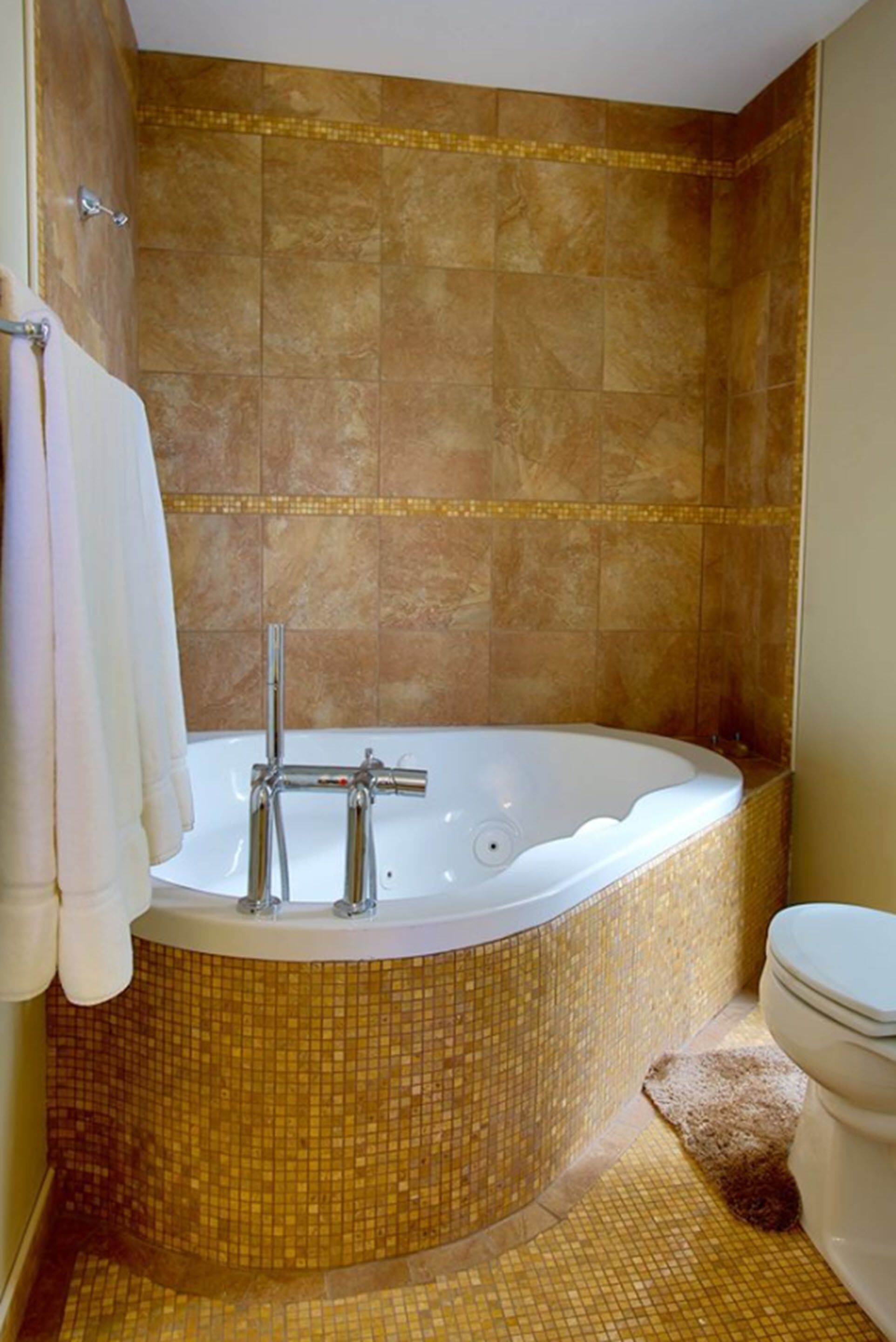 Un baño con una bañera independiente, un inodoro y una zona de ducha.