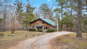 A rustic log cabin with a stone chimney, surrounded by a forest. - Rustic, close to buffalo river, secluded getaway, king bed, hiking ,WIFI (Jasper)