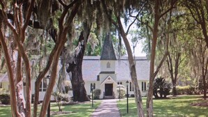 A church with a tall steeple, surrounded by trees and a pathway leading to the entrance. - St. Simons Island secret! (St Simons Island)