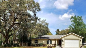 A single-story house with a garage, surrounded by a well-maintained lawn and large trees. - Custom home great local, boat parking,  near dock, food, scalloping,  Manatee. (Homosassa)