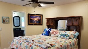 A bedroom with a bed, a ceiling fan, a painting, a dresser, and a mirror. - Custom home great local, boat parking,  near dock, food, scalloping,  Manatee. (Homosassa)