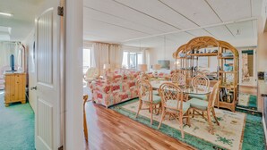 Zona pranzo con un tavolo rotondo, sedie e uno specchio decorativo.