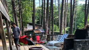 A wooden picnic table with a bowl and a grill in a wooded area. - Private Dock in Protected Cove (Edinburg)