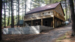 A two-story cabin with a balcony, surrounded by a forest. - Private Dock in Protected Cove (Edinburg)