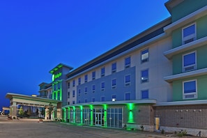 Ein mehrstöckiges Hotel mit schlichter Fassade, großen Fenstern und einem Holiday Inn Schild.