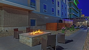A hotel exterior with a fire feature, outdoor seating, and a covered area with string lights. - Holiday Inn Amarillo East by IHG (Amarillo)