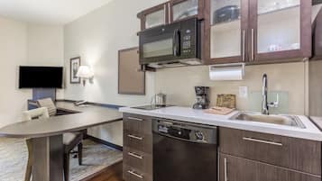 A modern kitchen with a built-in microwave, coffee maker, and dishwasher.