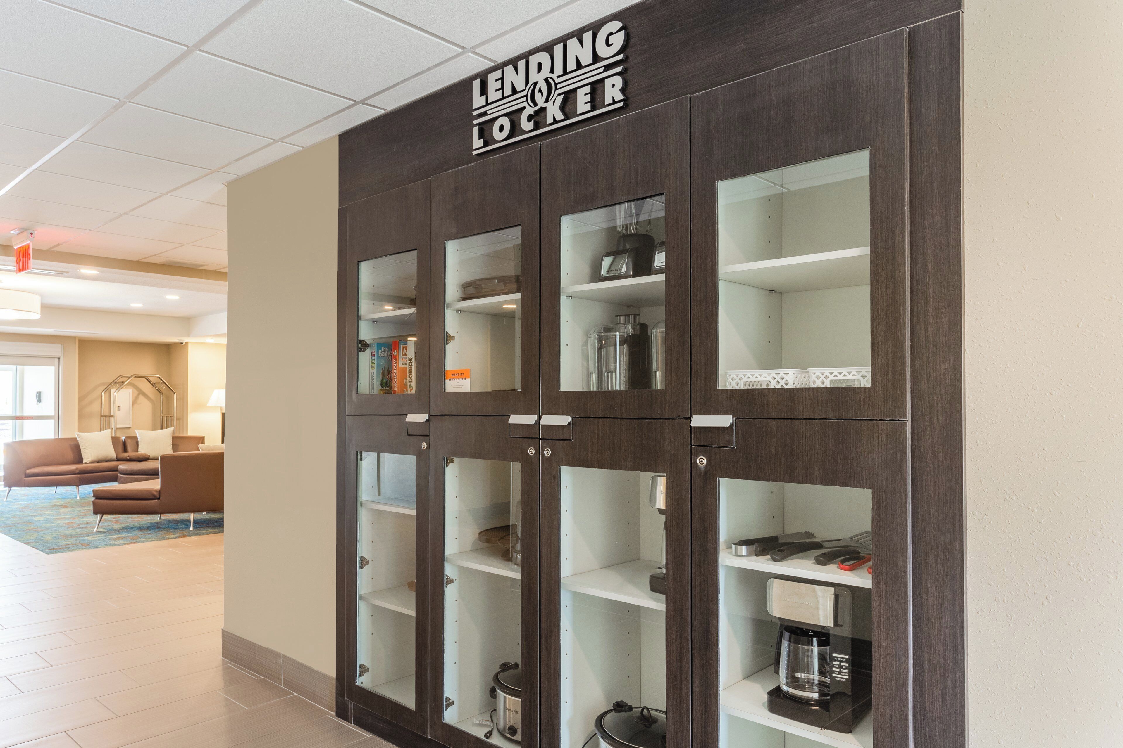 A LENDING LOCKER with multiple compartments, a coffee maker, and a kettle.
