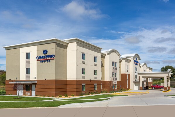 Een Candlewood Suites hotel met een modern ontwerp, herkenbaar aan een plat dak, grote ramen en een overdekte entree.