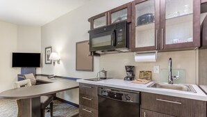 A modern kitchen with a built-in microwave, dishwasher, and a large island with seating.