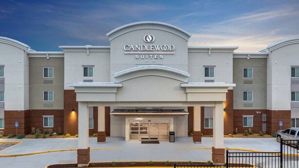A hotel entrance with a sign reading "CANDLEWOOD SUITES".