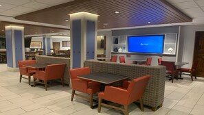 A modern restaurant with booths and tables, a TV screen displaying AT&T, and a wooden ceiling. - Holiday Inn Express & Suites Middletown by IHG (Middletown)