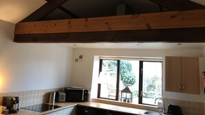 A kitchen with a wooden ceiling, a microwave, a toaster, and a sink. - Traditional Lakeland Hideaway Cottage for two, close to the Lakes and Dales (KENDAL)