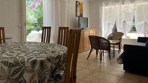 A room with a dining table, chairs, a TV, and a sofa. - BANDOL- Nice apartment - CLIM - 80 m from the SEA- 4 pers- 10 min walk from the center (Bandol)