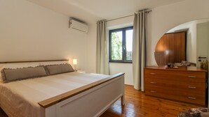 A bedroom with a bed, a dresser, a mirror, and a window with curtains. - Holiday house Roža * large garden, sun terrace, BBQ, free WiFi (Labin)