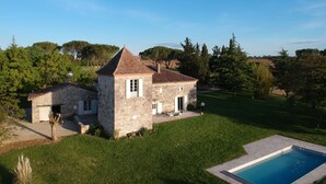 A stone house with a small tower, a swimming pool, and a well-maintained lawn. - 18th century Gersoise house, secluded, swimming pool, wooded grounds (La Romieu)