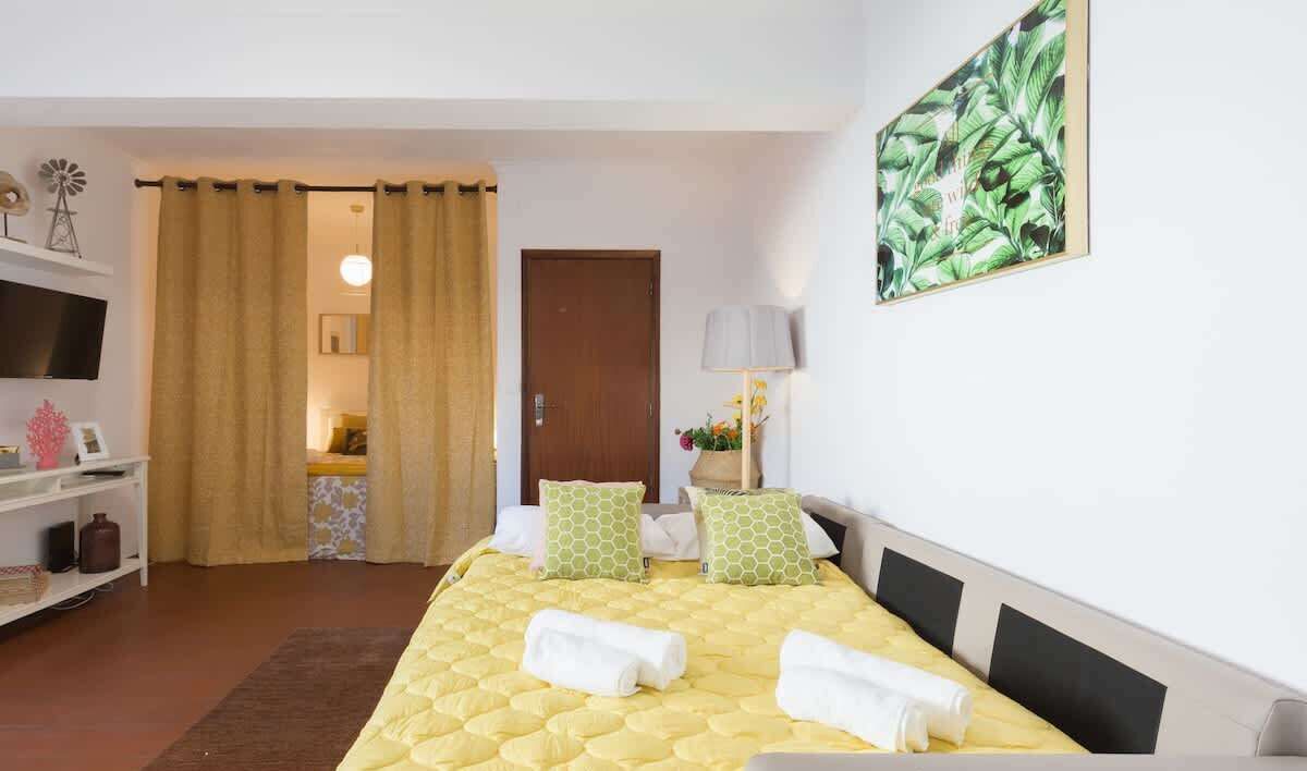 Une chambre d’hôtel avec un lit, une télévision, une lampe et un tableau.