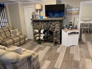 Cozy living room with a fireplace, flat-screen TV, and comfortable couch.