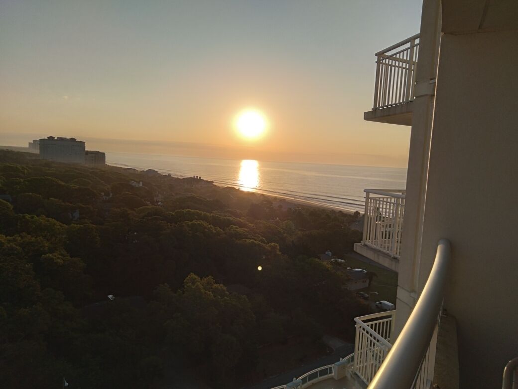 Ein Balkon mit Blick auf den Ozean bei Sonnenuntergang.