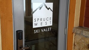 Una puerta con un panel de vidrio que muestra el texto "SPRUCE WEST SKI VALLET".