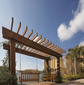 Relax beneath the pergola's shaded canopy, where a single swing invites you to unwind.