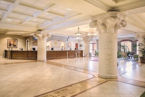 Experience the grandeur of our lobby, featuring ornate columns, a reception desk, and a comfortable lounge area.