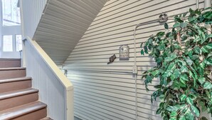 Un escalier avec une rampe, un panneau indiquant une buanderie et un tuyau fixé au mur.
