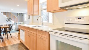 A modern kitchen with wooden cabinets, a white countertop, a built-in microwave, and a Whirlpool oven.
