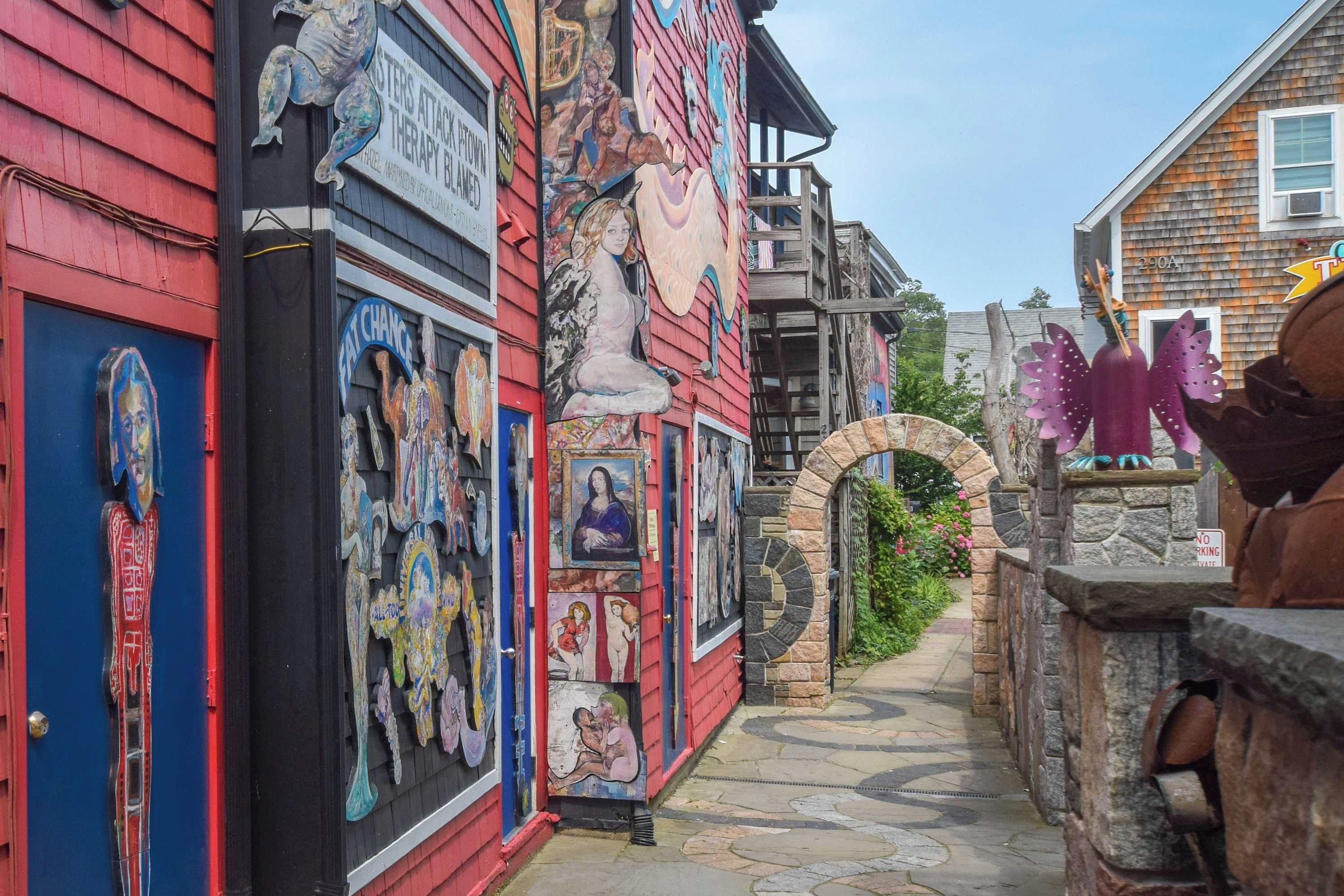 A narrow alley with colorful murals and a stone archway.