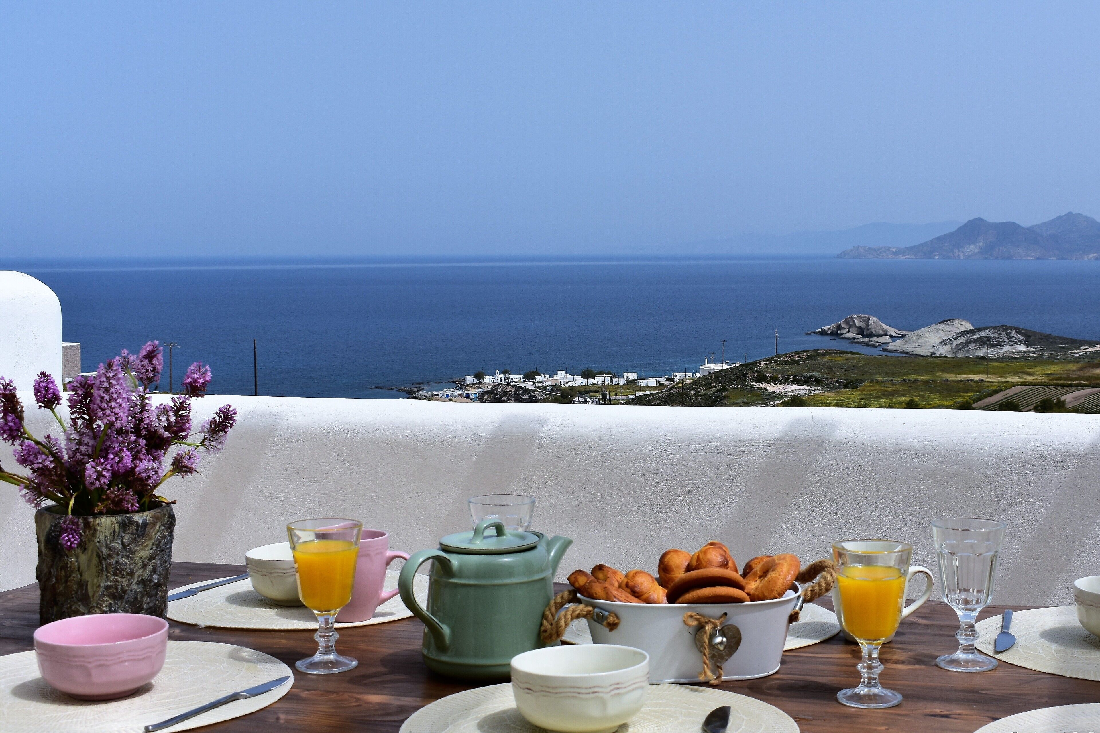 Ein Frühstückstisch mit Blick auf das Meer und die Berge.