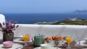 Un coin petit-déjeuner aménagé avec vue sur la mer et les montagnes.