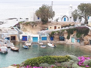 A coastal village with traditional architecture, boats docked at the harbor, and a church with a bell tower. - "Unique Sea View" traditionally decorated,minimal villa,huge terraces ocean view (Milos,The Cyclades)
