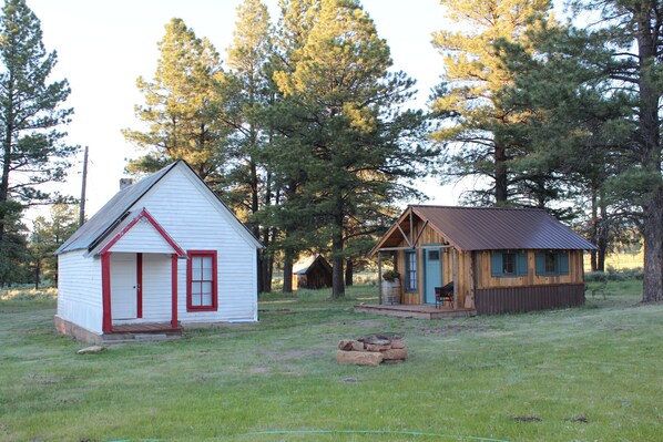 Two small cabins in a wooded area with a grassy field in front. - Beautiful Mountain Get Away 
at a Historic Old Schoolhouse (Montrose)