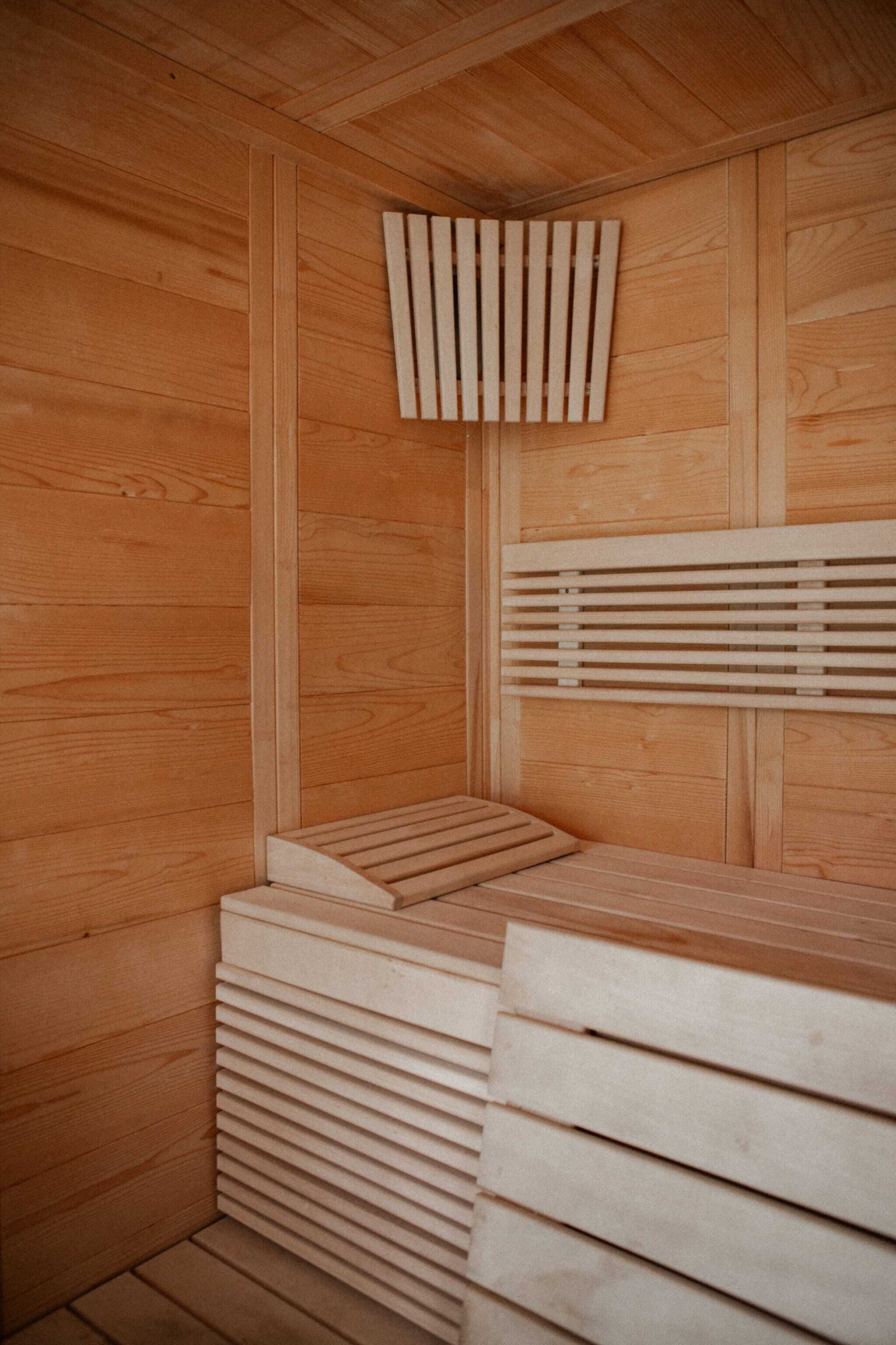 Un sauna en bois avec des bancs à lattes et un plafond en bois.