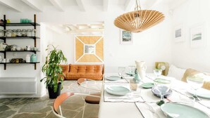 A dining area with a table set for four, a potted plant, and a bookshelf. - House center Guethary Maisons Dominos 1 (Guéthary)