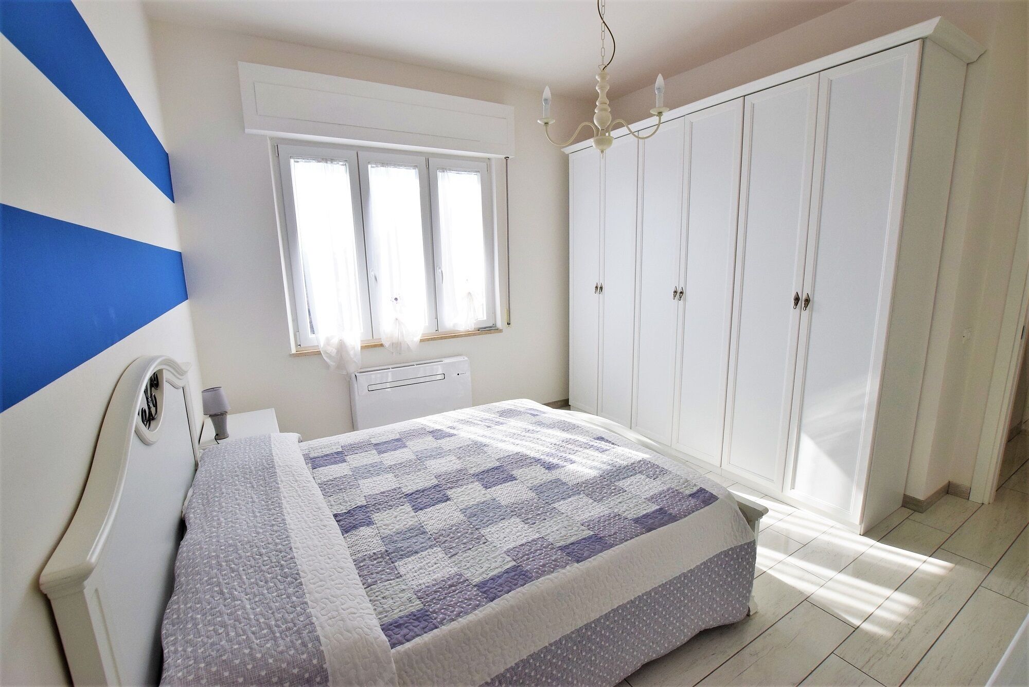 2 dormitorios y tabla de planchar con plancha