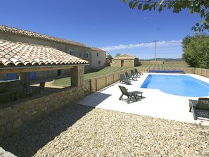 A pool area with lounge chairs, a stone building, and a clear view of the countryside. - Period Farmhouse, sleeps 12, large 12m x 6m pool, barn, big garden, courtyard (Verfeil)