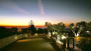 A pathway leading to a pool area with a sunset view, surrounded by greenery and stone walls. - Holiday home with garden near Balestrate Beach (balestrate)