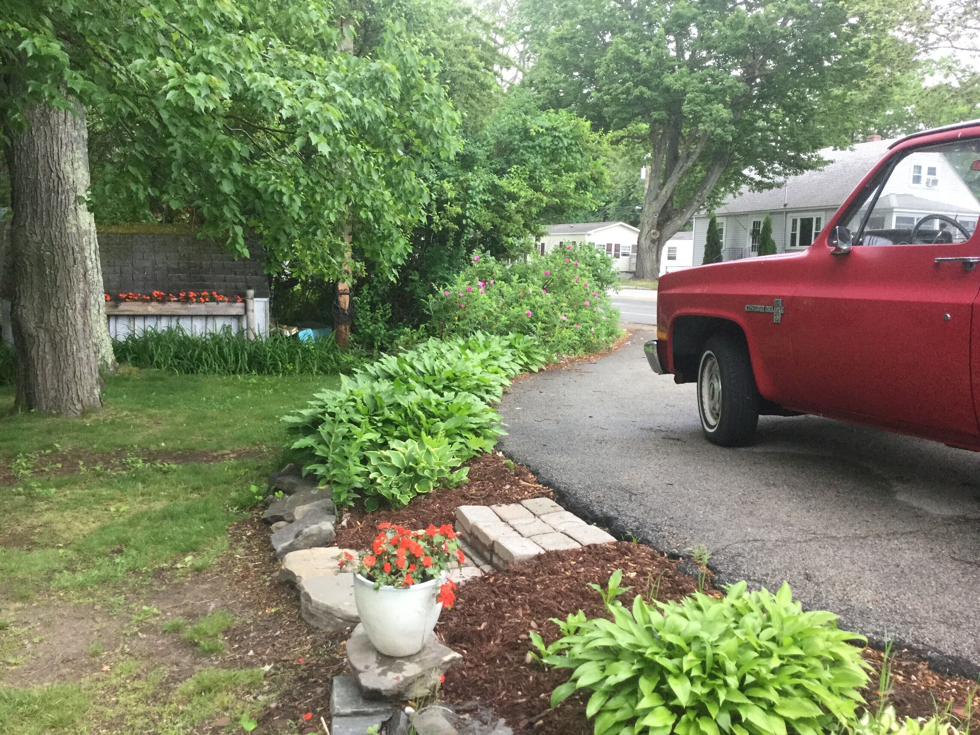 A red vintage car parked on a residential street.