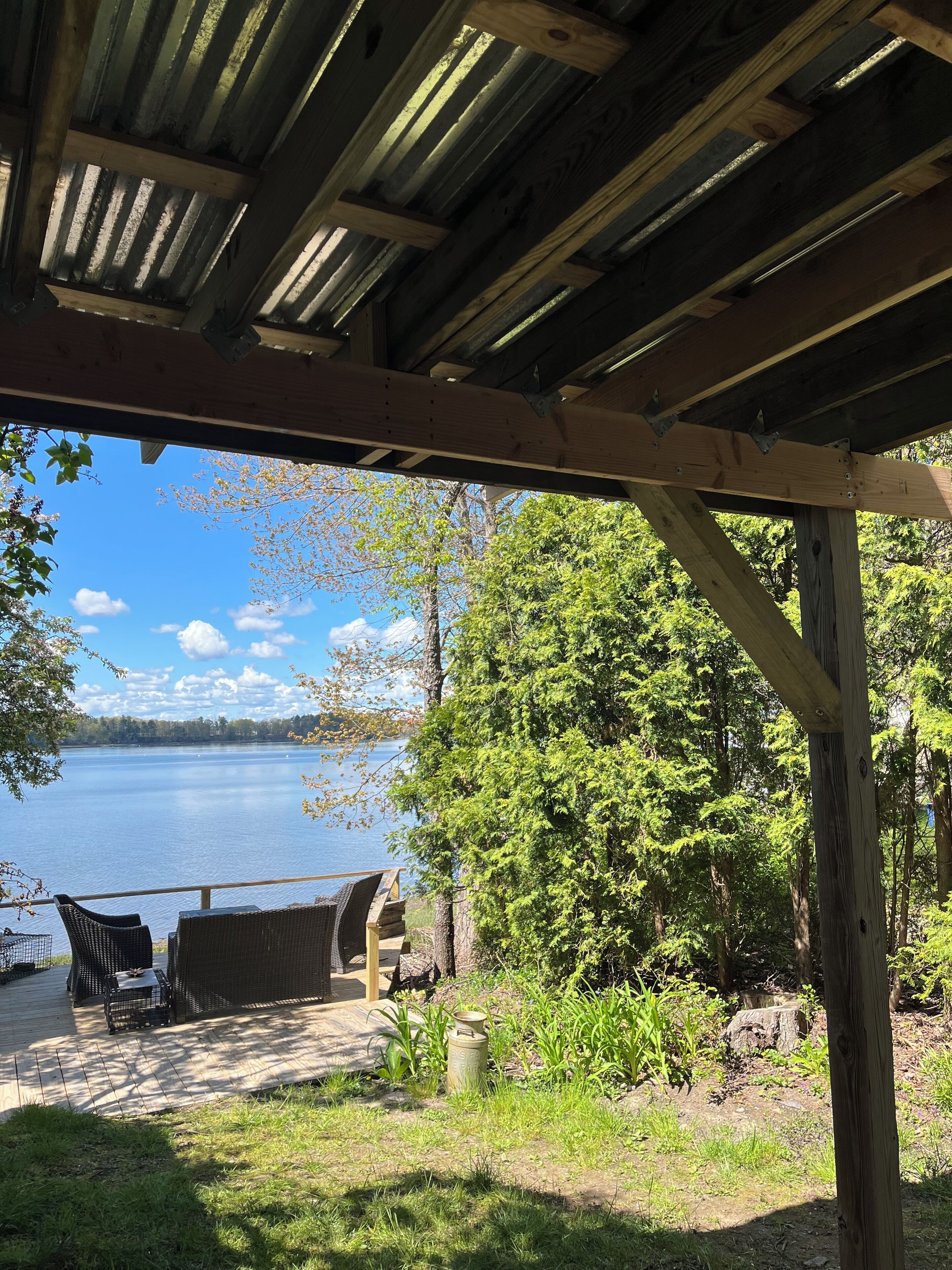 A wooden deck with outdoor furniture overlooking a lake.